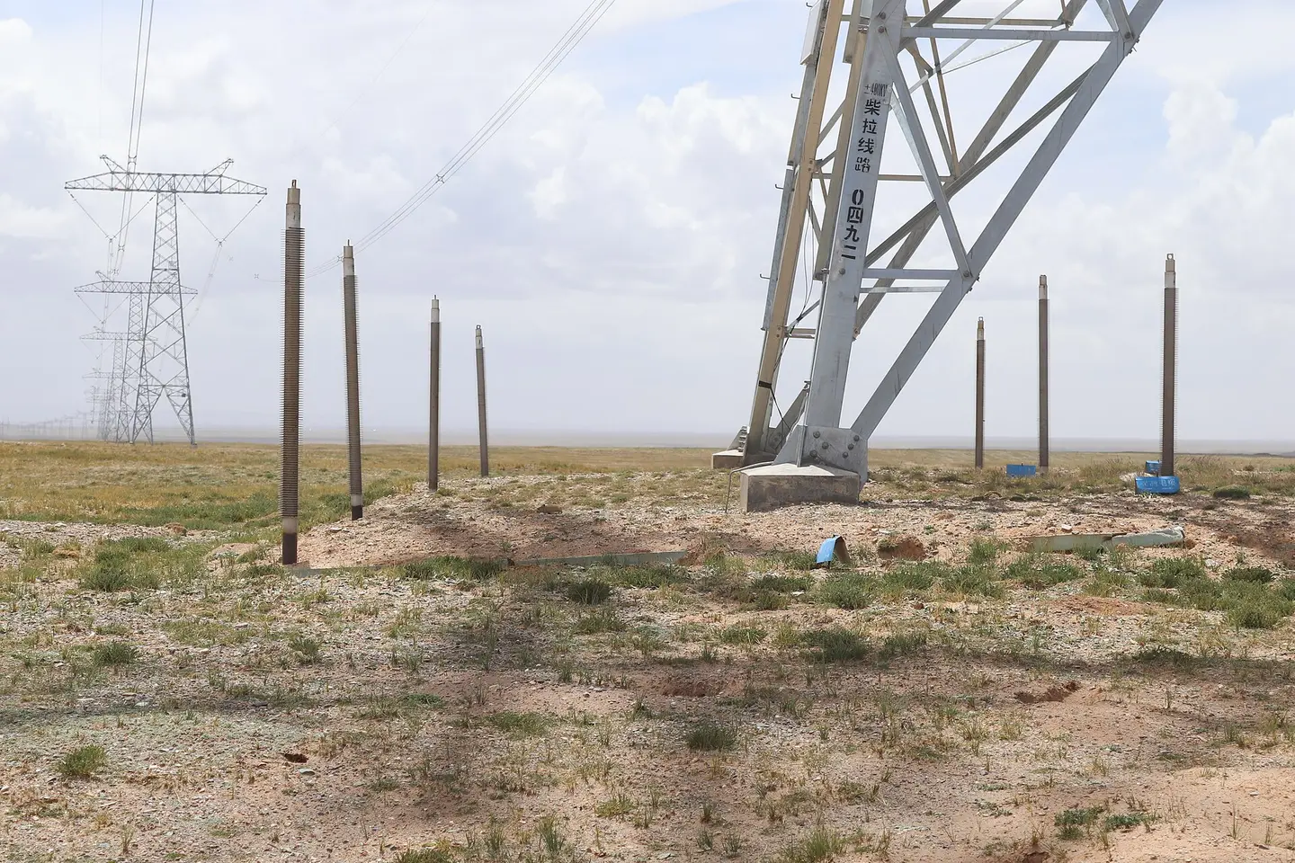 A Qinghai-Tibet high-voltage direct-current transmission tower and lines crossing open land in western China.