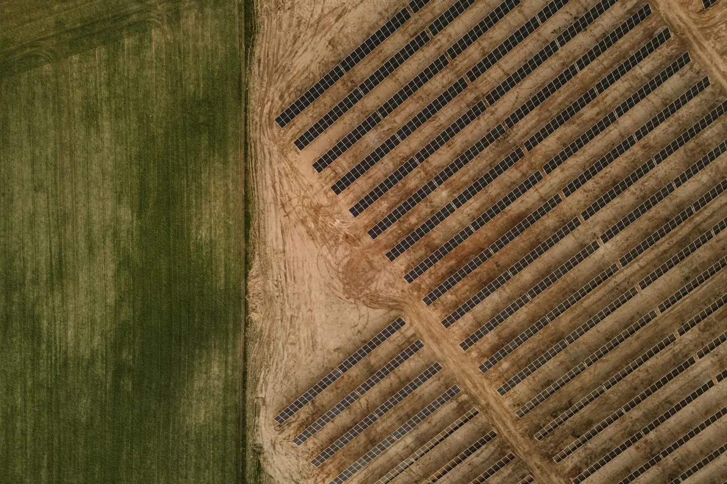 Aerial view of solar panels installed beside farm fields.